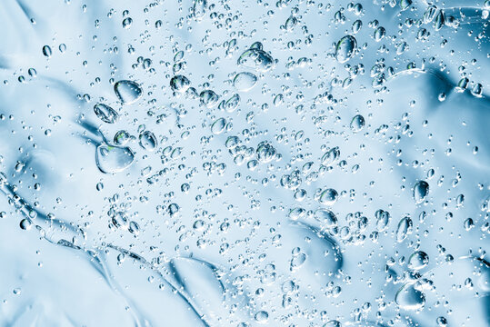 Close up macro Aloe vera gel serum cosmetic texture blue background with bubbles. Cruelty free. Lemongrass gel skincare product. antibacterial liquid with aloe vera, moisturizing.