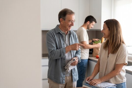 Multi-generational family members talking and doing chores in a bright kitchen