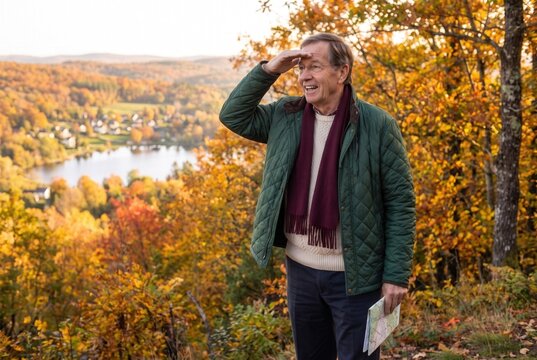 Senior man shielding eyes, looking into the distance during an autumn hike