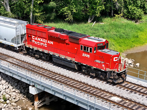 Savanna, Illinois June 22, 2026 Canadian Pacific 2326 locomotive in bright red livery on mainline track crossing a cement bridge pulling freight.
