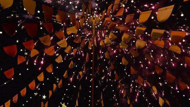 First rockets launching, fireworks bursting, canopy framing upward, flags glowing, for festival