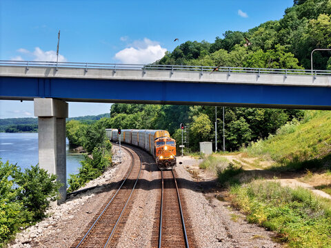Savanna, Illinois June 22, 2026 BNSF 7917 GE locomotive hauling auto‑rack freight cars on mainline track heading under a bridge into Savanna, Illinois