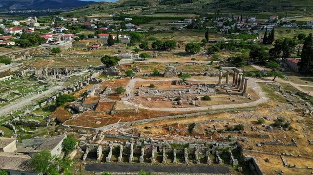 Aerial view of the ancient ruins and stone columns of the Temple of Apollo at the archaeological site of Ancient Corinth, Greece.