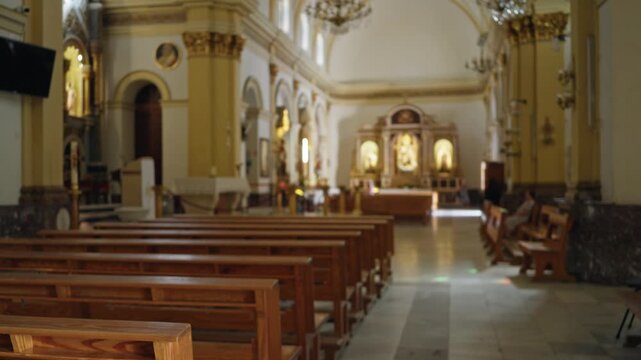 Blurred church interior with shallow bokeh and warm wooden pews leading to softened altar; background backplate copyspace calm.
