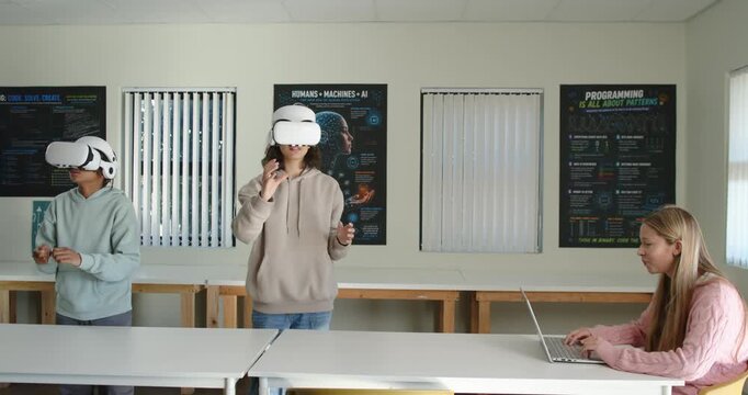Diverse teens seeing teen walking in donning white VR headset interacting with virtual app in lab