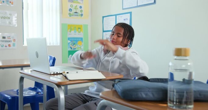 African American teen reaching for pink headphones, arranging laptop and notebook at school desk