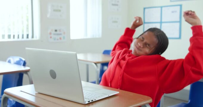 African American teen red hoodie typing at school stretching after typing, closing laptop resting