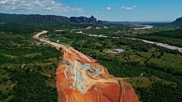 An aerial perspective of a large-scale railway infrastructure project under development in the scenic rural landscape of Greece, captured on May 26, 2024.