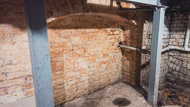 Reinforcing old brick basement walls with steel beams during restoration