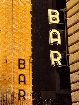Shadow of the sign "bar" on the wall in the afternoon
