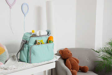 Baby bag with accessories on changing table in room