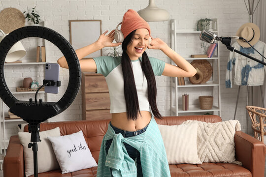 Teenage blogger in headphones recording video at home
