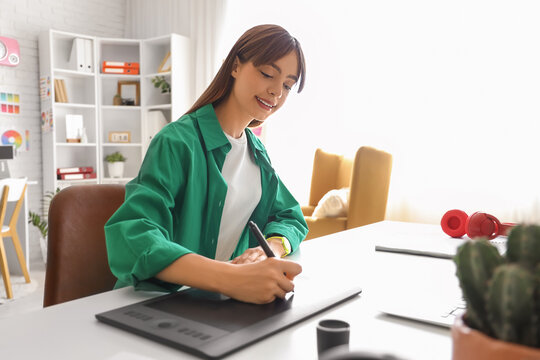 Graphic designer working with tablet at table in office