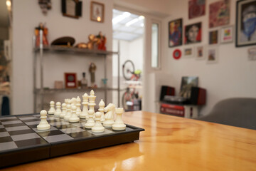Chess game on wooden table in bright modern living room © Pablo