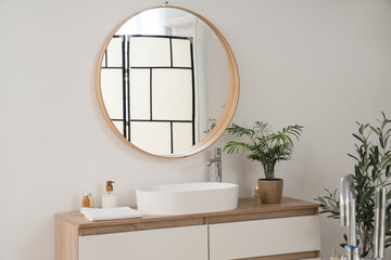 Obraz premium Sink with cosmetic products and palm on drawers in bathroom
