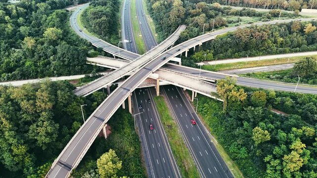 Aerial view of Connecticut highway interchange with traffic through green forest, representing transportation infrastructure, commuting, mobility, and regional connectivity.
