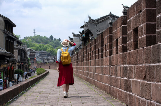 Young female tourist looking at the beautiful landscape of Feng Huang Ancient Town, The famous tourist destination at Hunan Province, China