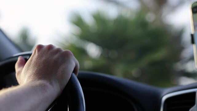 Man resting hand on steering wheel in parked car ready to drive. Closeup, 4k