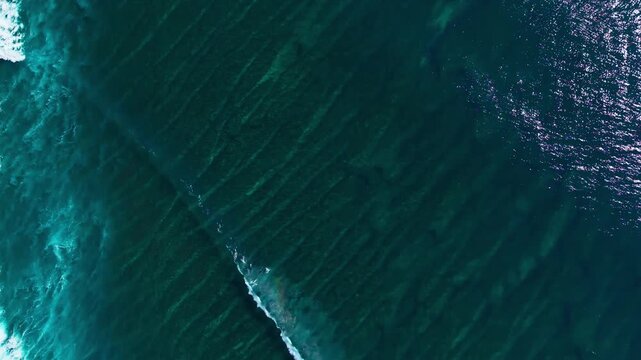 Top Down Aerial View of Ocean Waves Breaking Over Coral Reef