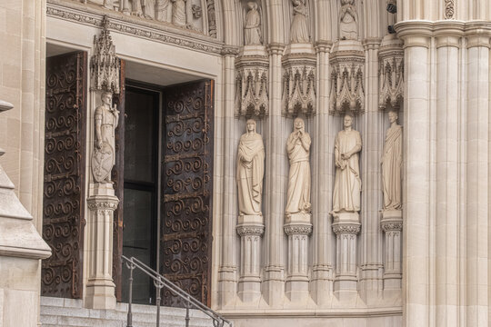 Washington, United States - 06 May 2025: View of the intricate stone carvings and statues at the entrance of the Washington National Cathedral.