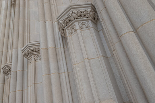 Washington, District of Columbia, United States - 06 May 2025: View of intricate Gothic Revival stone columns and carved capitals on the exterior of the Washington National Cathedral.