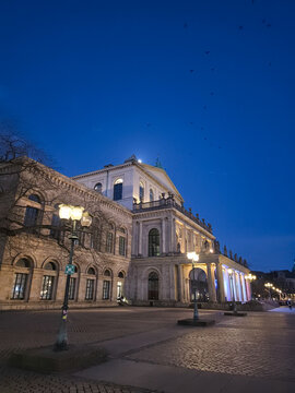 Hanover, Germany - 30 March 2026: View of the illuminated Hanover State Opera at twilight with street lamps and a clear blue sky.