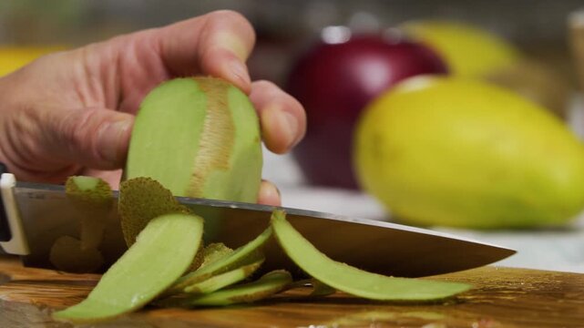Closeup, slow motion shot of kiwi being shaved