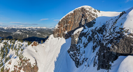 Snow-Covered Granite Peak and Alpine Ridge Overlooking Forested Mountains in British Columbia, Canada © edb3_16