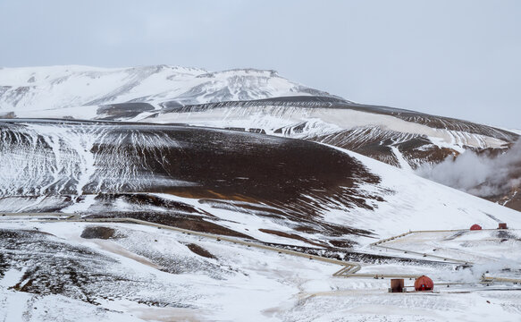 Krafla power geothermal plant snow and ice covering volcanic slopes with steam vents. Iceland sustainable energy