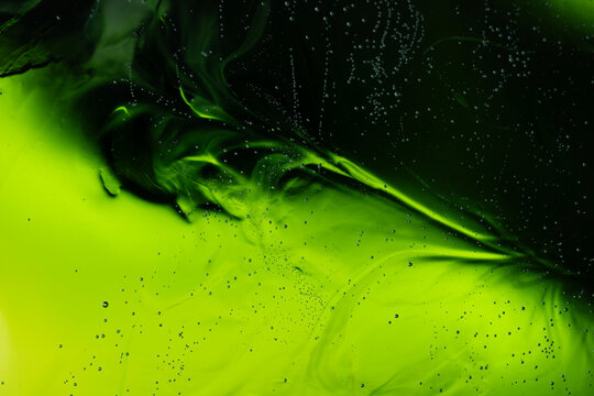 Green liquid flowing creating abstract swirl patterns