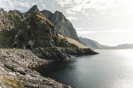 Bleik, Norway - 01 September 2025: View of the coastal road and tunnel entrance carved into the rocky mountainside overlooking the sea in Bleik.