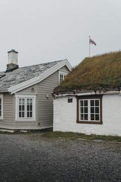 Vardo, Finnmark, Norway - 25 August 2025: View of traditional wooden houses with a sod roof and a shingle roof under an overcast sky in Vardo.