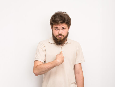 Bearded young man pointing at himself with confident expression on white background, concept of self introduction, personal branding and identity.
