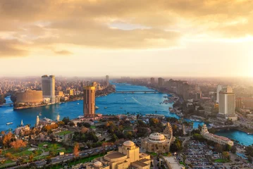 Panoramic bird's eye view of Cairo skyline at sunset with modern skyscrapers along the Nile river, Egypt © AlexAnton