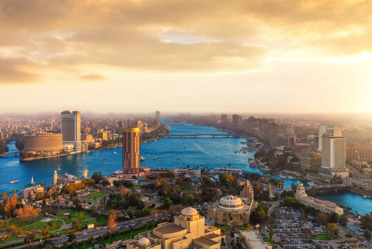 Panoramic bird's eye view of Cairo skyline at sunset with modern skyscrapers along the Nile river, Egypt