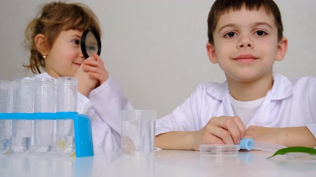 Laboratory examination of a child with test tubes, reagents and a microscope. Selective focus.