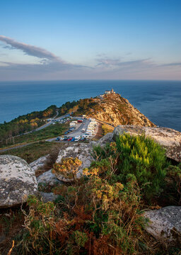Breathtaking landscape a headland and lighthouse on the slope of rocky cliff, on the blue ocean and sky