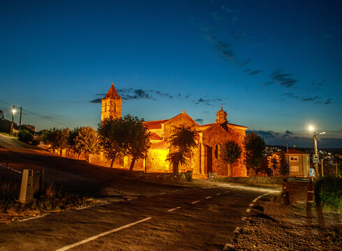 Night-time landscape against the backdrop of evening sky, with Catholic church illuminated by streetlights