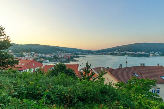 Evening view of seaside town and a bay, set against the backdrop of sunset sky