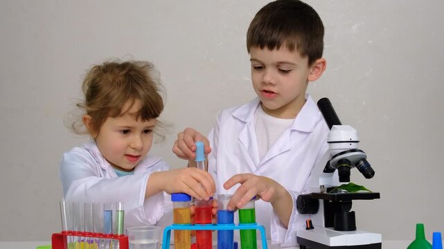 Laboratory examination of a child with test tubes, reagents and a microscope. Selective focus.