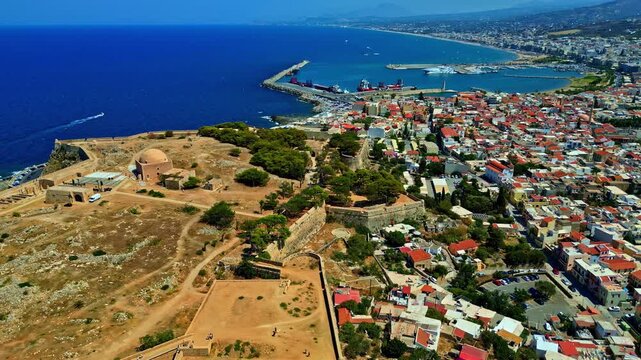 Aerial view of the historic Fortezza of Rethymno overlooking the Mediterranean Sea and the coastal city with red-tiled rooftops in Rethymno, Greece.