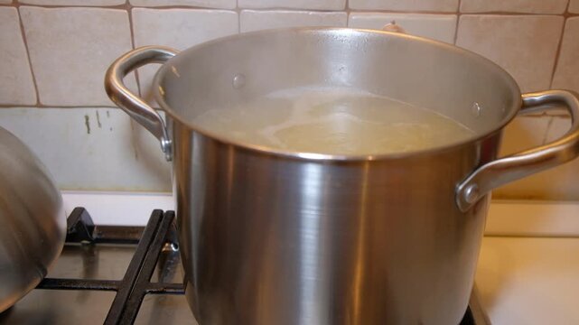 The process of cooking jelly in the apartment of the house you can see the product boiled meat of a person's hands a woman stirring food