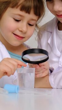 Laboratory examination of a child with test tubes, reagents and a microscope. Selective focus.