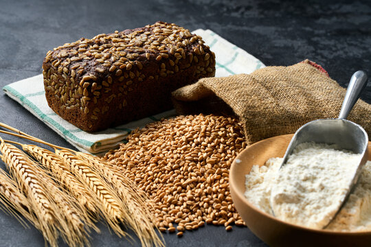 Danish rye bread made from sourdough with whole grain flour and seeds on dark kitchen table
