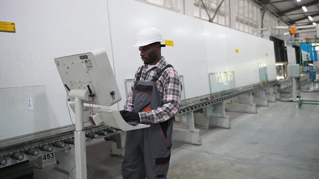 Industrial engineer operating a cnc glass cutting machine