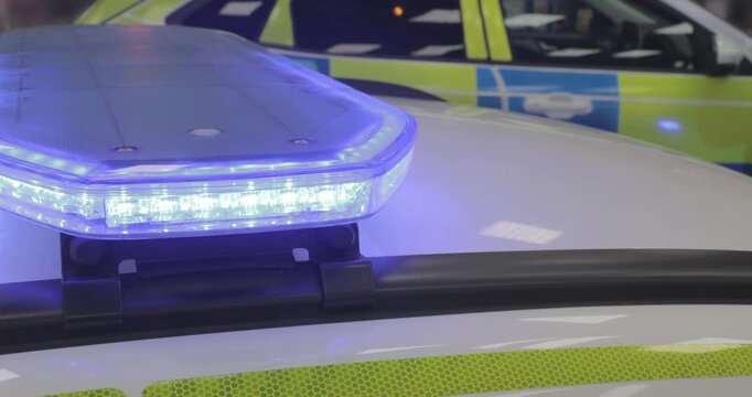 Police car lights - blue flashing emergency services siren from police vehicle lightbar. Used in pursuit or response to a crime scene or incident. Officers enforce law and order and protect public.