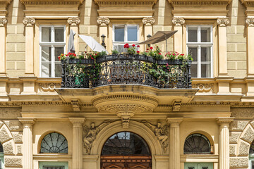 Flower-filled balcony with a wrought iron railing on a historic apartment facade on Széchenyi utca in Budapest, Hungary © GuillaumeAngleraud
