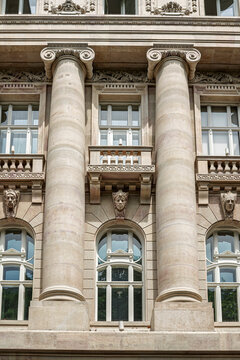 Ionic columns with lion-head keystones flanking arched windows on the Hungarian National Bank facade in Budapest, Hungary