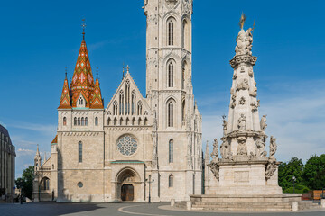 Obraz premium Wide view of Matthias Church and the Holy Trinity Statue across the stone plaza in Budapest, Hungary