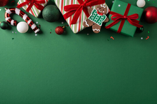 Merry Christmas and Happy New Year gifts with gingerbread cookie and ornaments on green background
